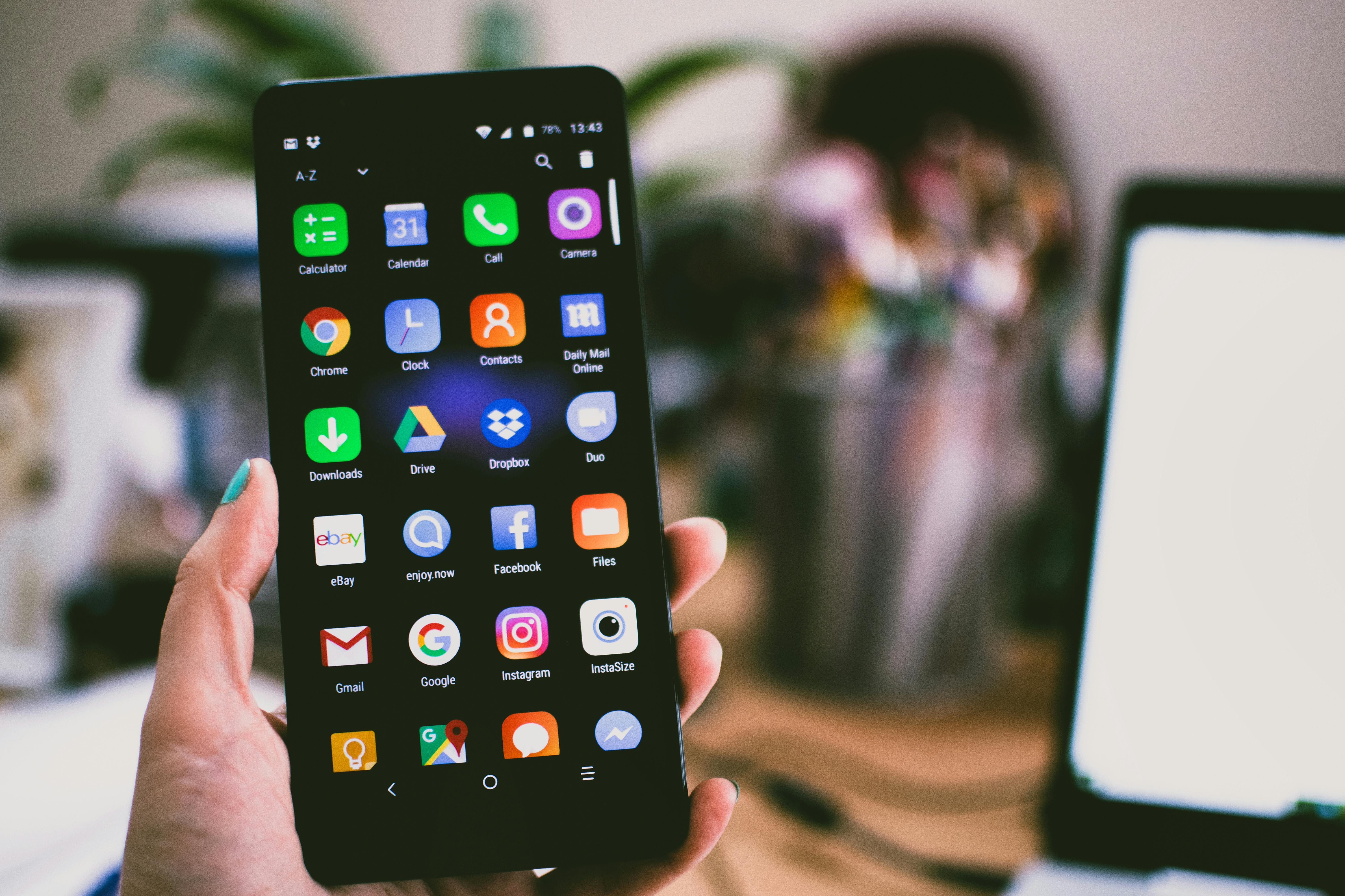 personne tenant un téléphone avec des applications mobiles connus apparente